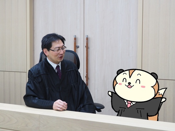裁判官とさいたんのイラストが会話している写真